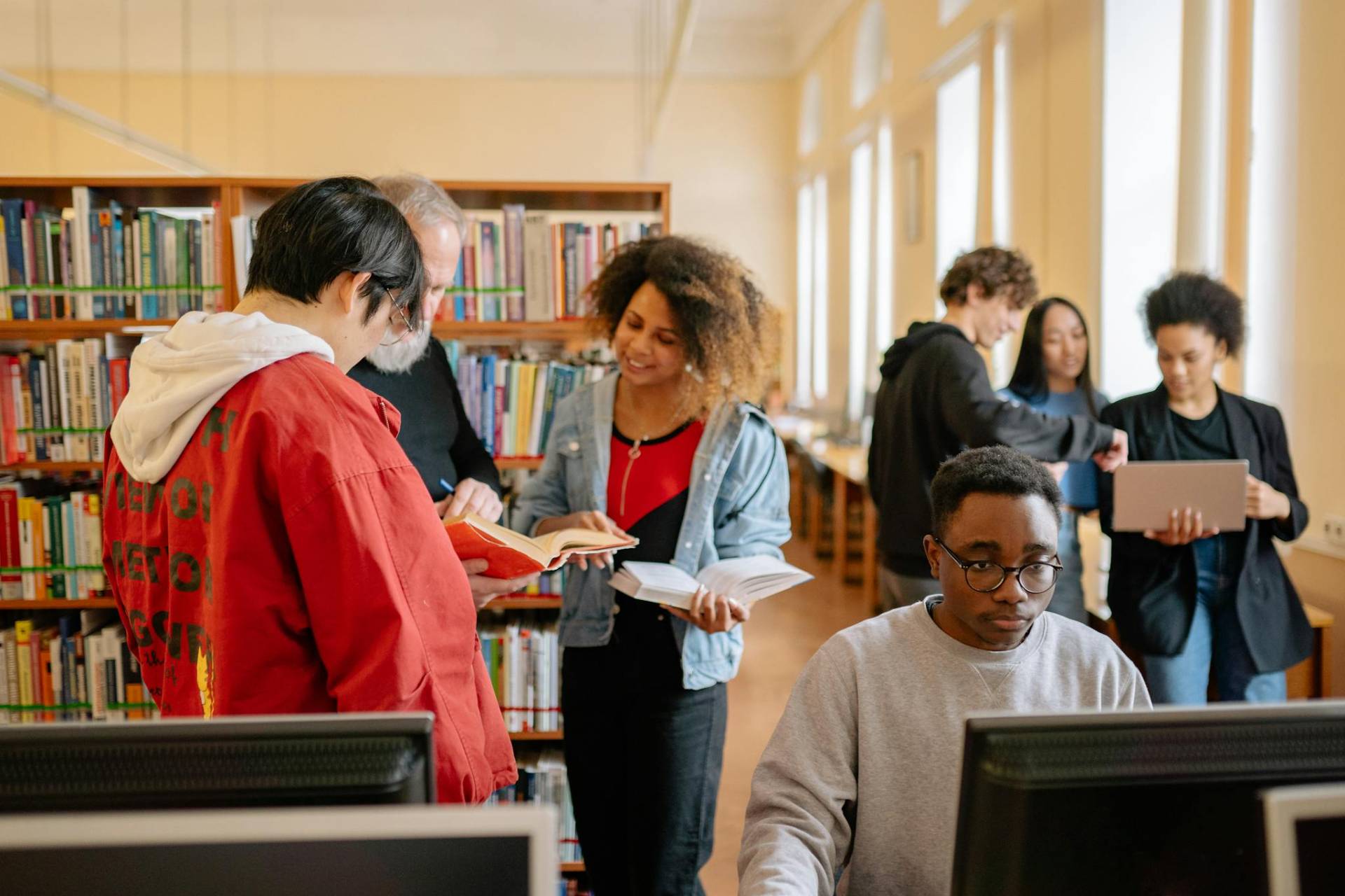 Students collaborating and studying in a library, fostering education and diversity.